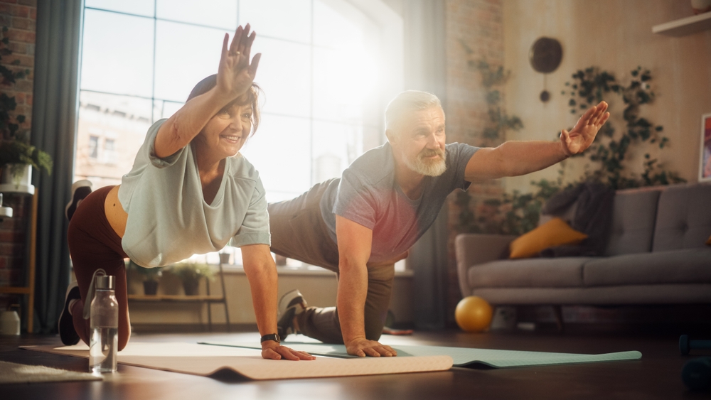Happy,Middle,Aged,Couple,Doing,Gymnastics,And,Yoga,Stretching,Exercises 1764955758 8e6658a097db4c5cb27f0c854f57b380 1